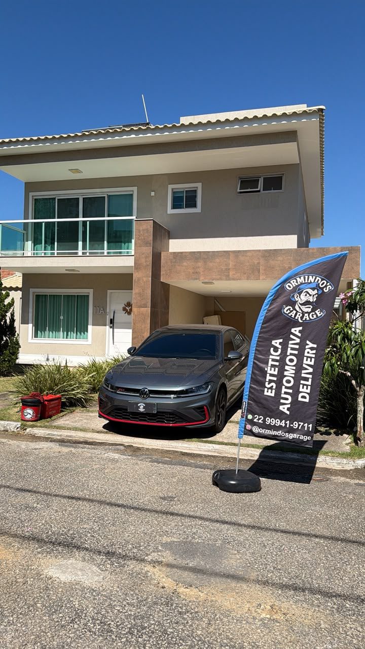 Carro finalizado em frente à residência com bandeira de estética automotiva delivery