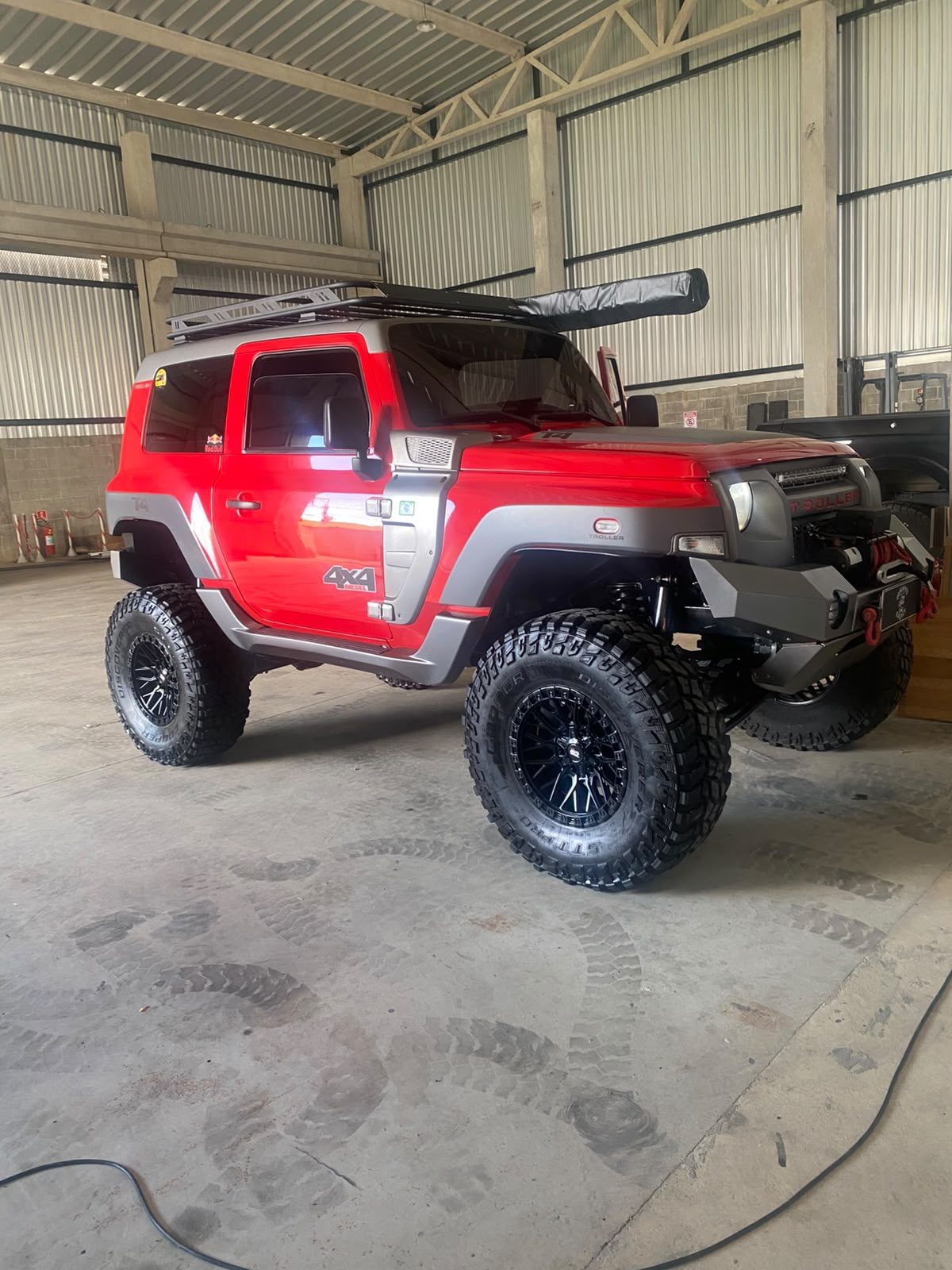 Jeep vermelho finalizado em área coberta após serviço de estética automotiva
